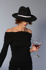 woman with black dress and wine and mafia hat