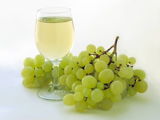 glass of white grape wine and grapes