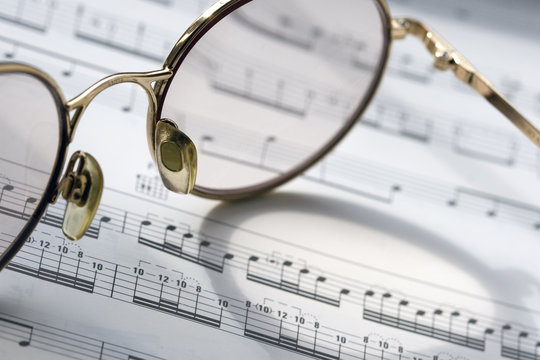 pair of glasses on sheet music