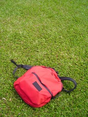 single red bag against grass field