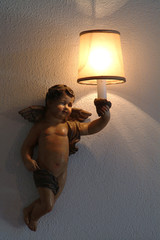lighted lamp in the hand of an antique  angel