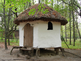 Fototapeta na wymiar white small rural log-house in a park