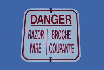 bilingual danger razor wire sign
