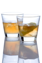 two whiskey glasses against white background
