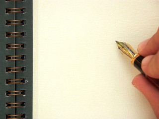 main et stylo écrivant sur une page blanche
