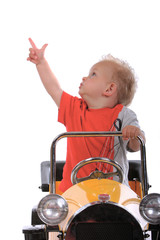 blond boy driving a toy car