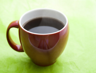red coffee cup on green background