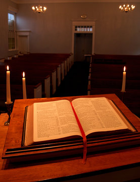 bible on pulpit with candles - vertical