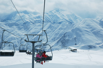 skiing lift with people and mountains