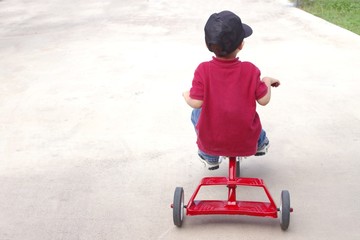 boy riding a tricycle
