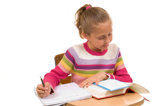 Young Girl At Desk In School On White