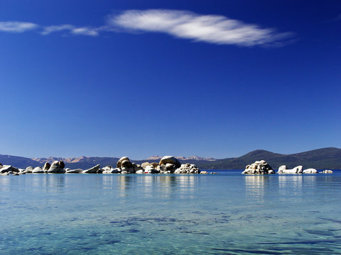 Beach in Lake Tahoe, rocks in clear transparent water with blue sky