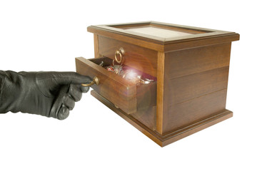 hand in black glove opening casket with jewelry