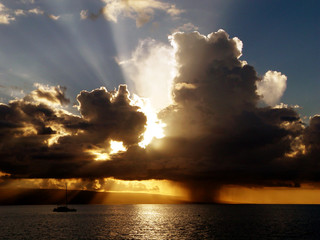 Naklejka na ściany i meble dramatic tropical sunset, sun rays with rain 