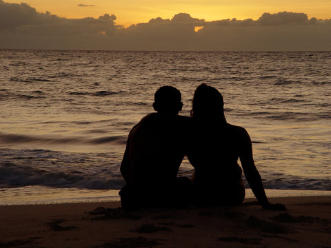 couple on the beach watching sunset, romatic date on island