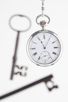 silver pocket watch and keys