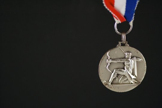 medal with archer and black background