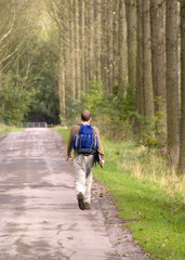 young man walking along country road