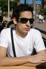 Fototapeta premium young man sitting with sun glasses
