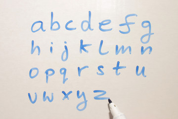 writing the alphabet on a teachers whiteboard.
