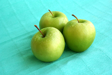 three deluxe wet green apples