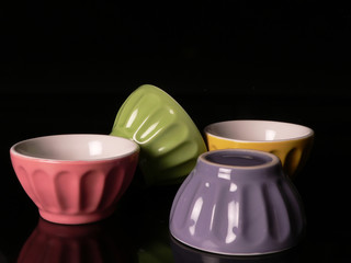 colored cups in a black background