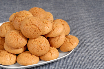 plate of italian amaretti cookies on a blue placemat