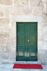 Fototapeta na wymiar Tradycyjne zielone drzwi przednie i czerwony dywan