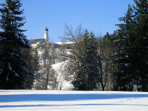 church on hill, behind snowy meadow