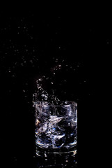 splash in a glass of water on black