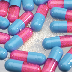 blue and pink pîlls with little white balls in it