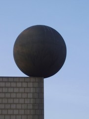 sphere on the edge of grey wall