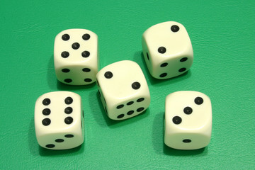 five white dice on a green background.