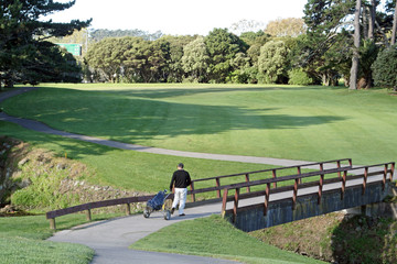 golfer walking on a bridge