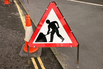 british roadwork’s sign and red cone on the side o