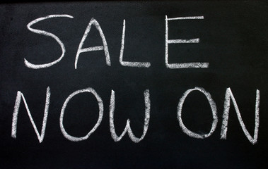 sale now on, written on a blackboard.