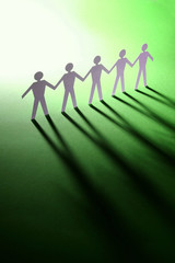 cut-out figures standing together over a green bac