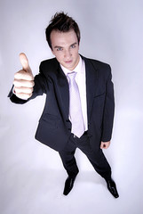 Young businessman in suit showing thumb up