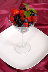 fresh berries topped with mint in a martini glass