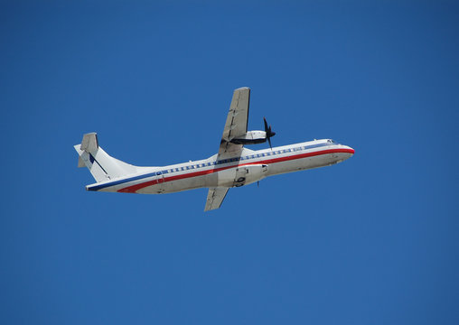 white turboprop airplane aginst blue sky