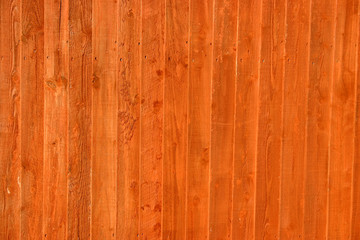 wooden stained fence with a strong orange color.
