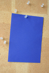 blue paper sheet pinned to corkboard