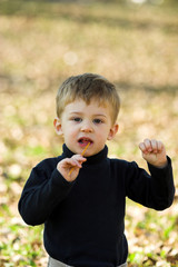 Fototapeta premium a little boy eating short stick