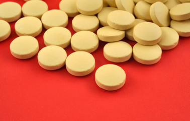 handful of yellow tablets on red