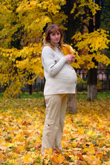 pregnant woman in autumn park hold maple leaf #5