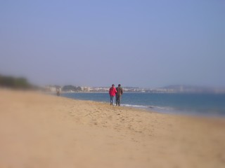 lovers arm in arm on deserted beach