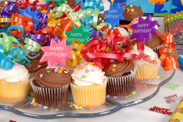 closeup of a platter of cupcakes decorated with happy birthday t