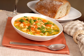 bowl of chicken noodle soup with rustic bread