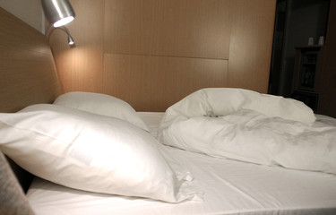oreillers dans un lit aux draps froissés