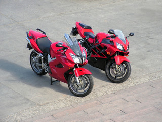 two red beautiful motorcycles .